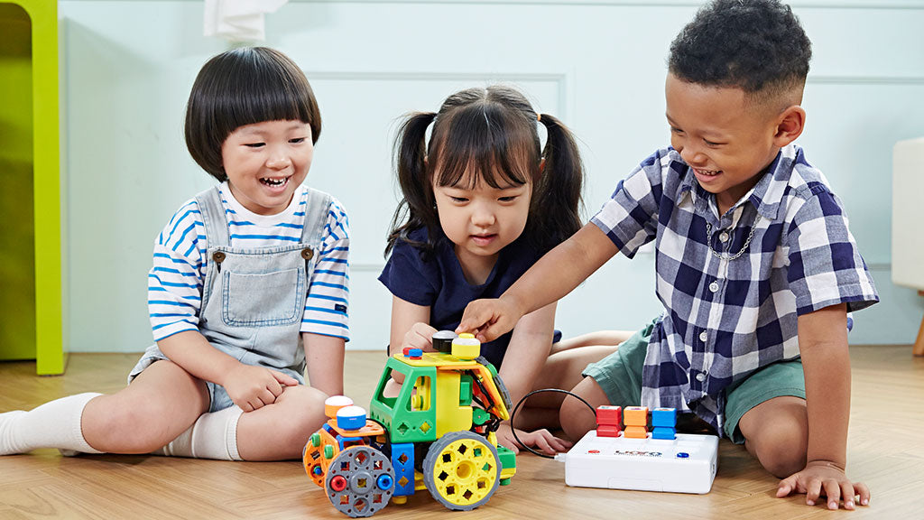 3 kids playing with Buildy Bots