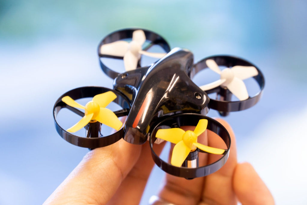 A CoDrone Mini being held by fingers with new propelelrs