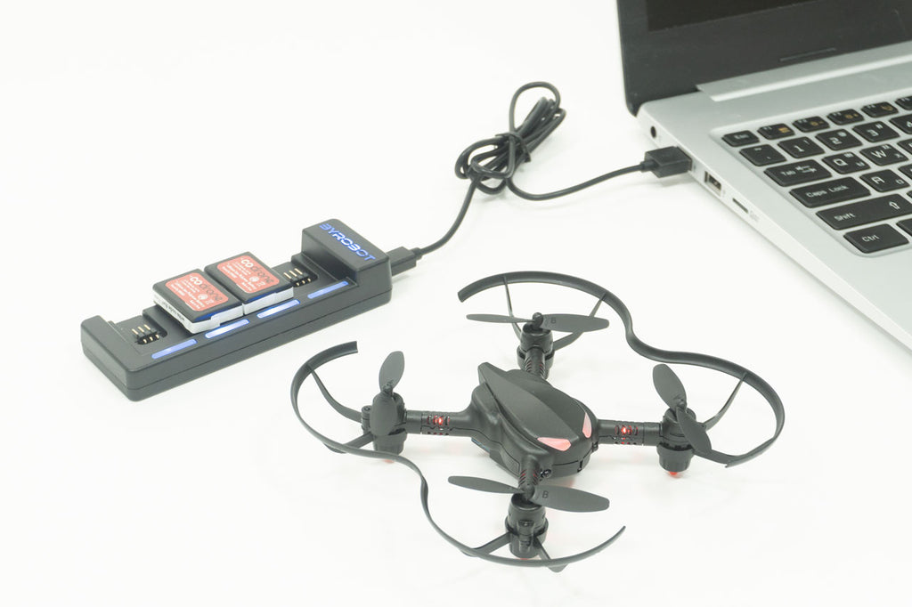 The CoDrone Pro with the Power Pack plugged into a laptop charging 2 batteries