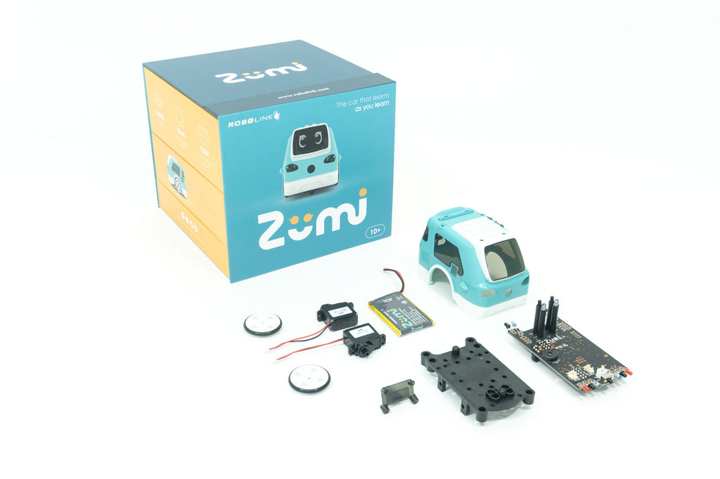 Zumi items inside the box laid out in front of a box, including motors, wheels, the battery, the chassis, and the main PCB board.